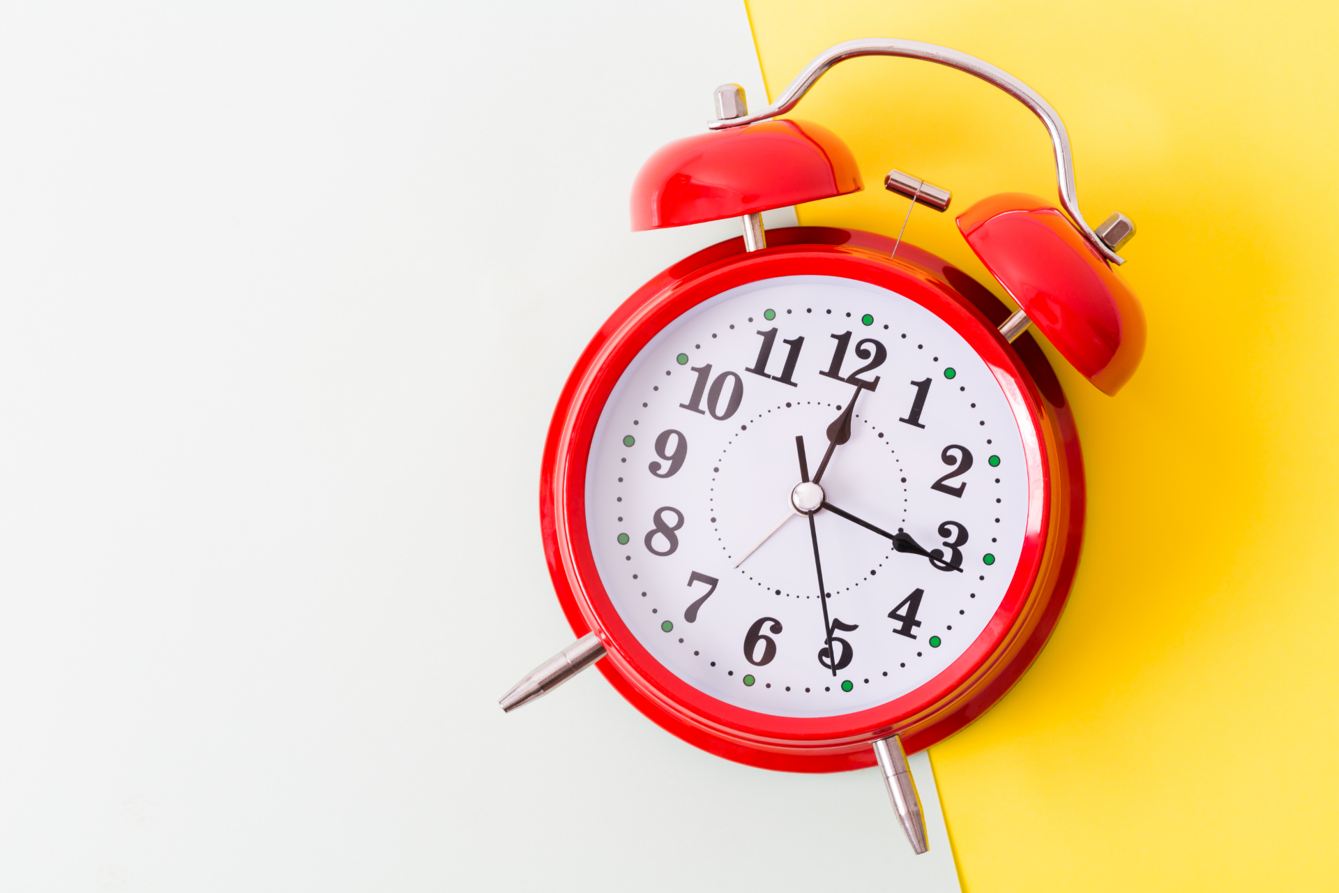 red vintage clock on a white and yellow background