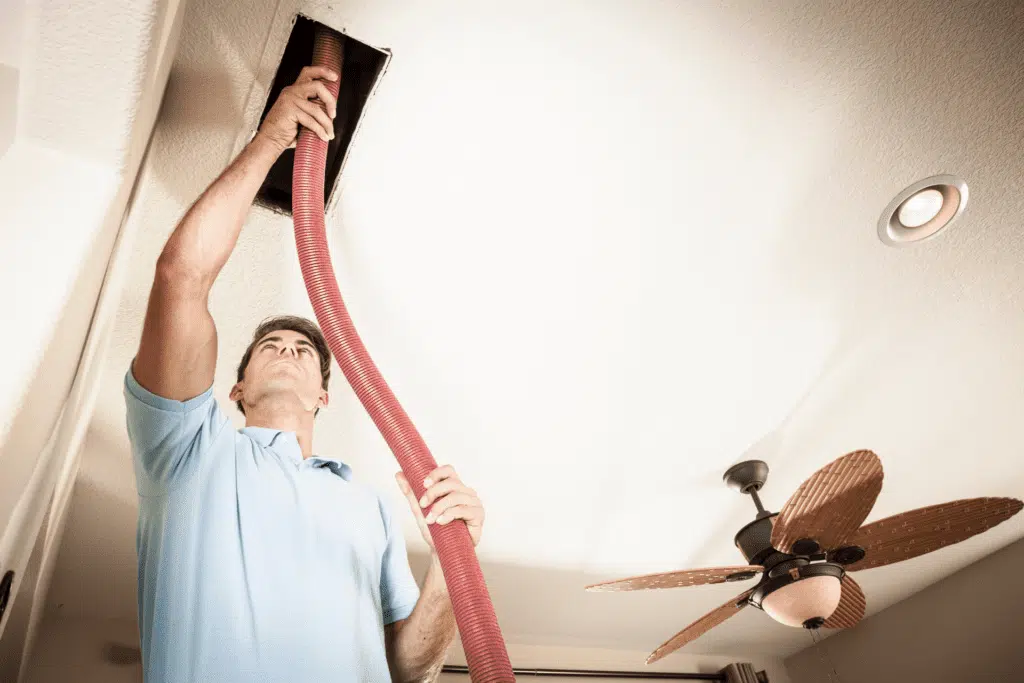 A technician cleaning a home air vent, improving indoor air quality and HVAC efficiency.