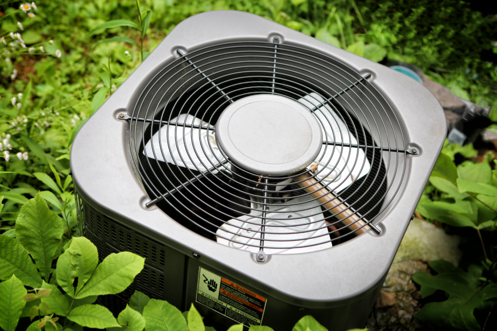 outside air conditioning unit surrounded by leaves