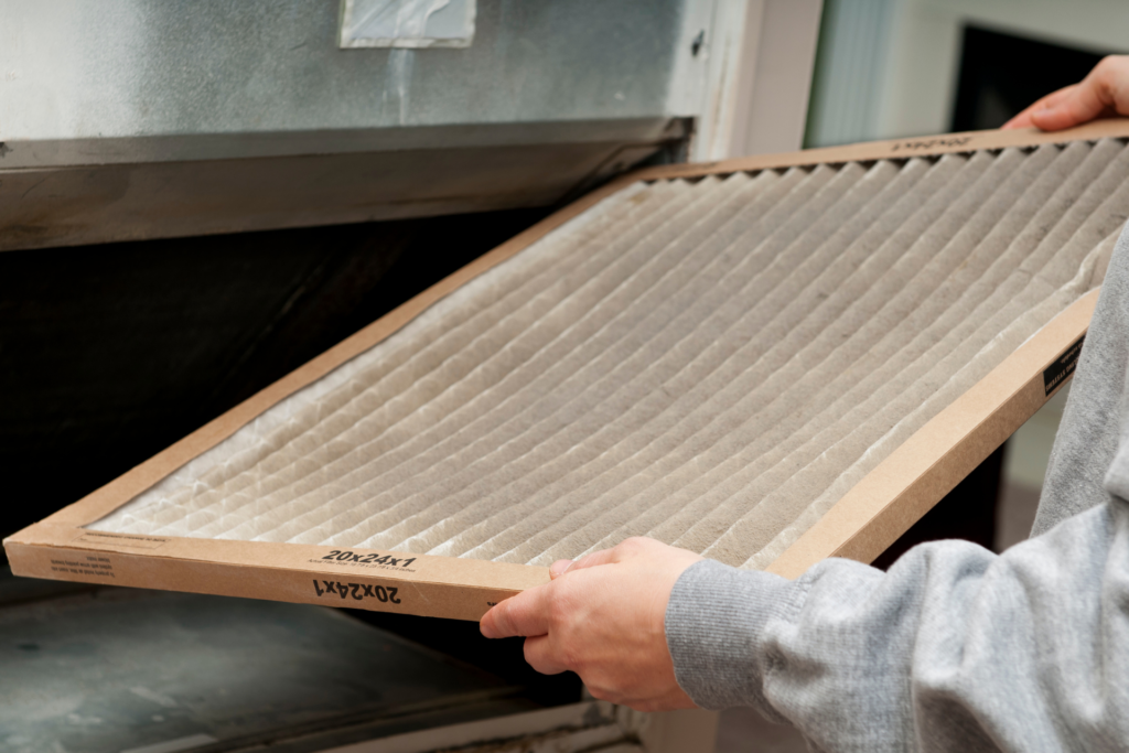 man removing dirty ac filter in residential house