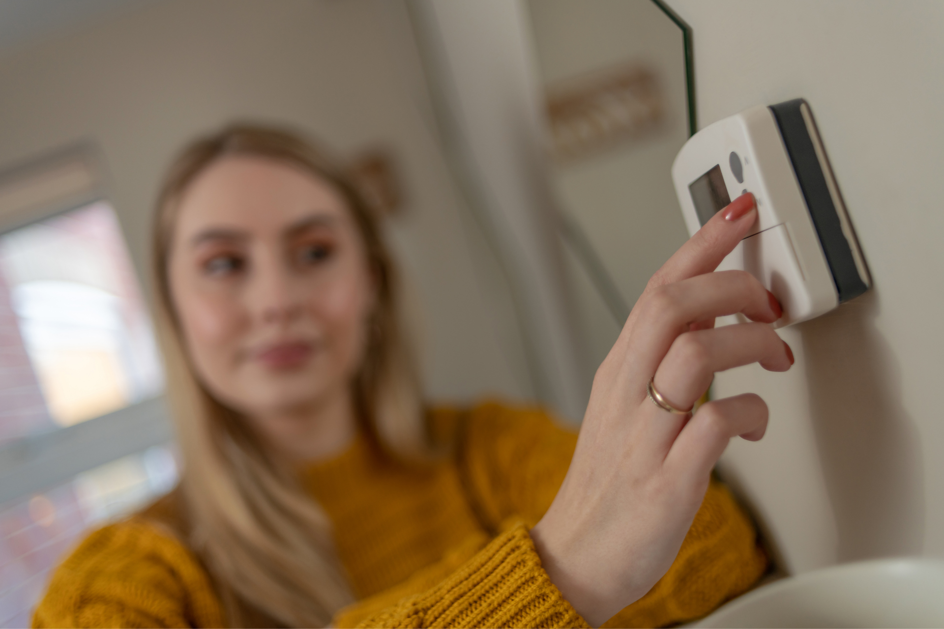 girl changing the thermostat in house