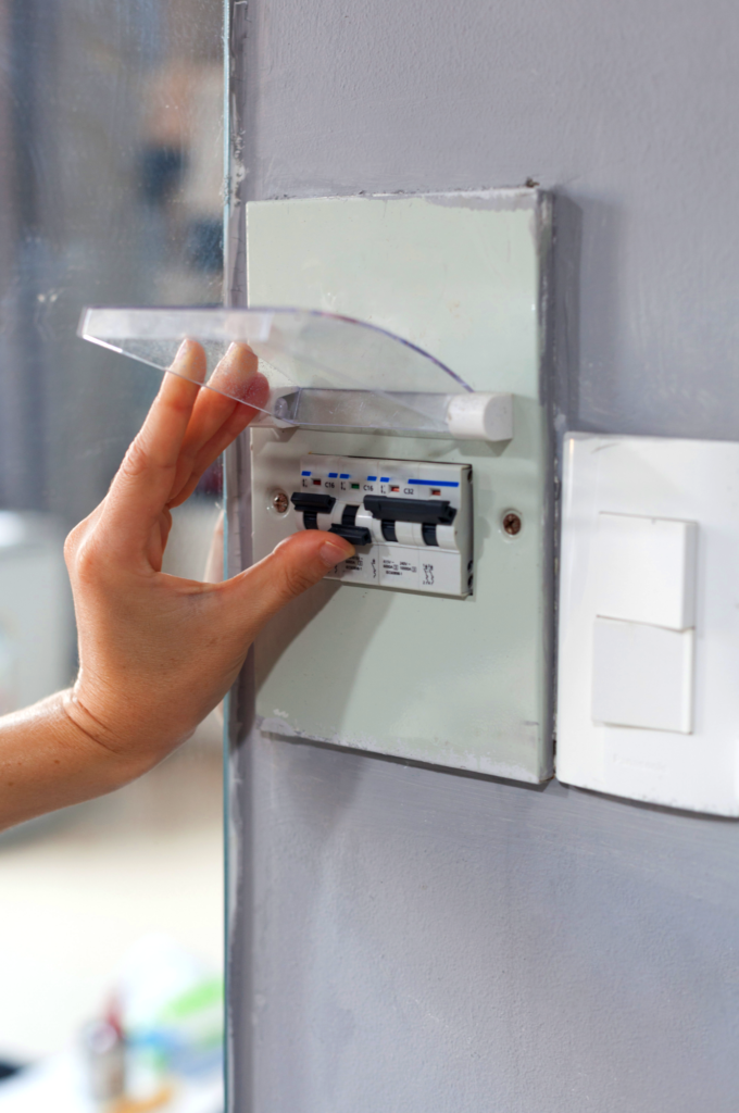 person flipping circuit breaker for AC off after power outage