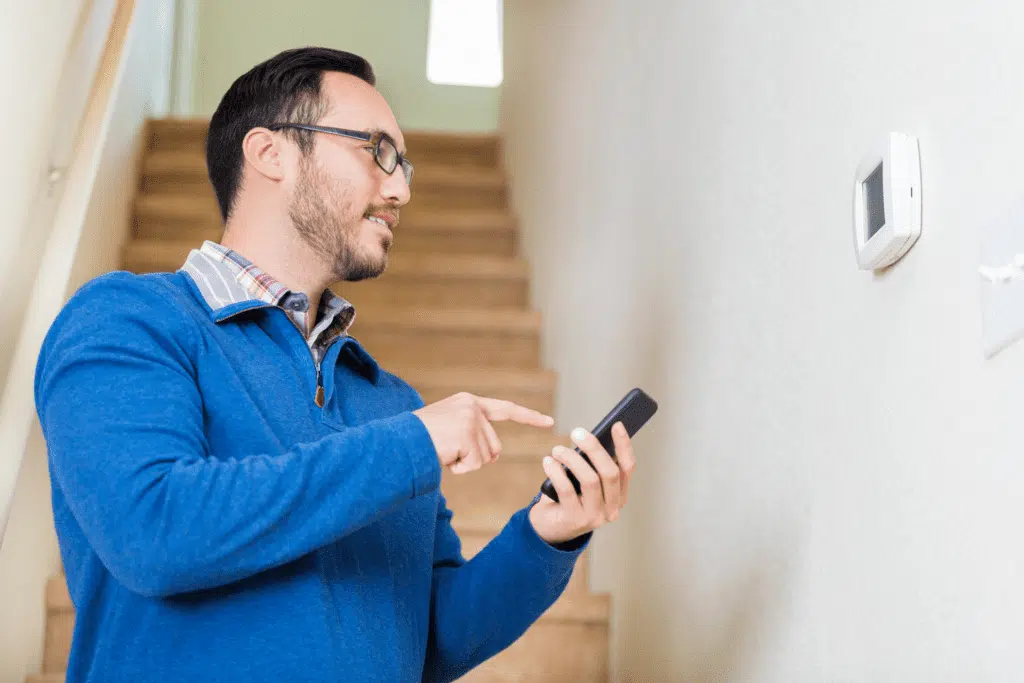 Nashville homeowner adjusting his smart thermostat over WiFi